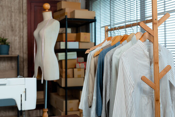 An online clothing store with shirts hanging on a rail and a mockup of a human body in the...