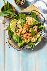 Healthy food concept. Diet summer salad plate. Shrimps salad with arugula, grilled zucchini and walnut. View from above. Copy space.