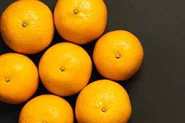 Flat lay with natural tangerines in round shape isolated on black.