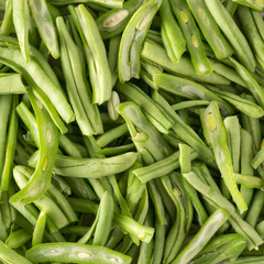 pile of cut and cleaned green beans, also known as french beans, string beans or snaps, vegetable preparing for cooking, food background