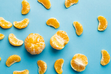 Top view of peeled mandarins on blue background.