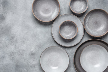 Handmade ceramics, empty gray craft plates. Gray grunge background. Top view, flat lay, copy space.
