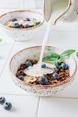 Chocolate granola and milk with blueberries, banana and mint. Healthy food