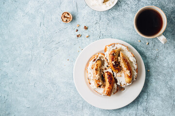 Fried Caramel Banana Sandwich with nuts and cream cheese on blue concrete background.