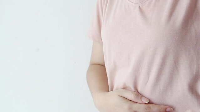 Woman standing with hands on stomach, abdominal pain, flatulence, indigestion, congestion, colic