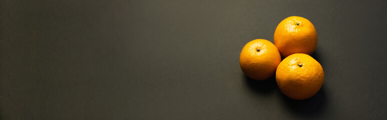 High angle view of tasty tangerines on black surface, banner.