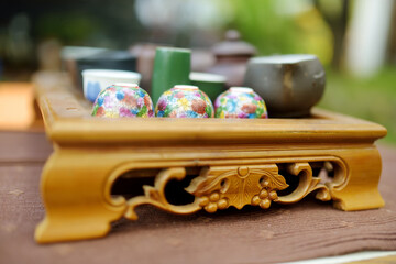 Tea pot and several cups on wooden table for traditional chinese tea ceremony.