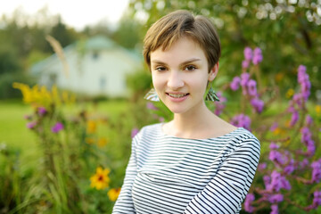 Cute young girl having fun outdoors on sunny summer evening. Child exploring nature.