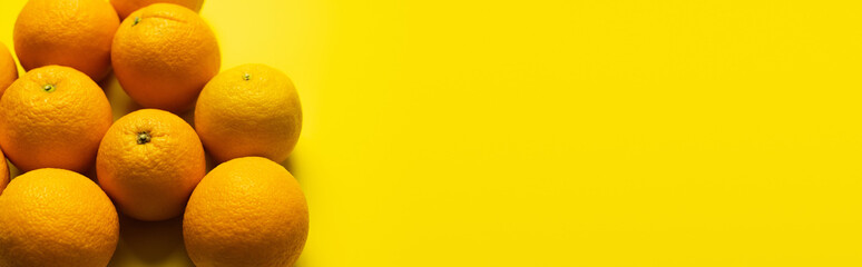 Top view of sweet oranges on yellow background with copy space, banner.