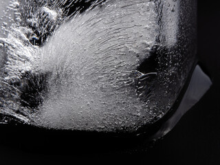 Ice cube on black background. Close up real melting ice cube.