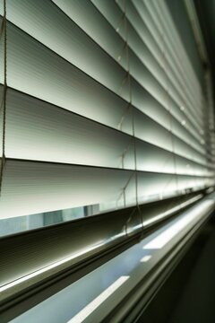 Vertical closeup of white blinds closing a window