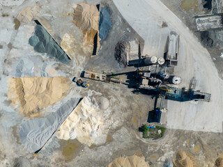 Sandpit and Factory Plant Aerial View. Producing of sand materials for construction industry, granite - gravel pit. Equipment for processing and crushing stones. Land destroyed by industrial activity.