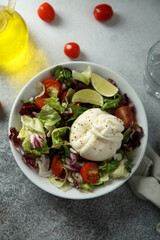Healthy green salad with tomato and burrata cheese