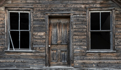 Obraz na płótnie Canvas Old wooden door and windows of abandoned home