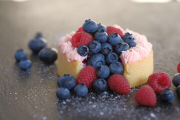 Cake with cream covered with juicy berries.