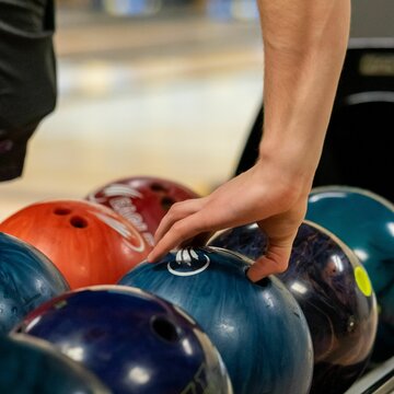 Closeup Shot Of A Hand Picking Up A Bowling Ball