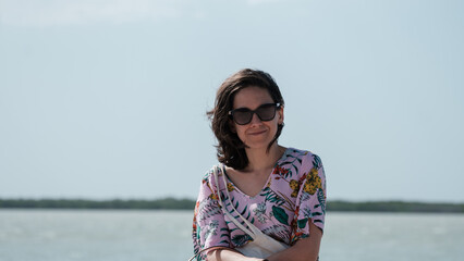 beautiful girl with sunglasses, sat in front of the Caribbean sea