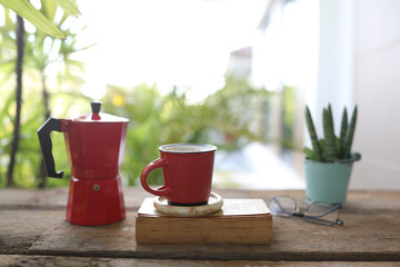 Red coffee cup and red moka pot and book and plant pot