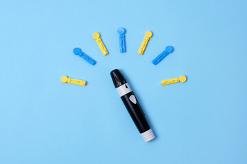 Diabetes concept on blue background. An abstract clock made of interchangeable needles and a lancet for blood sugar testing. - obrazy, fototapety, plakaty