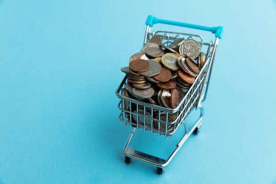 Shopping cart full of UK sterling coins. Cost of shopping concept
