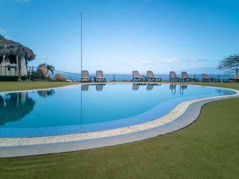 View Of A Swimming Pool Reflecting Beach Chairs And An Alcove