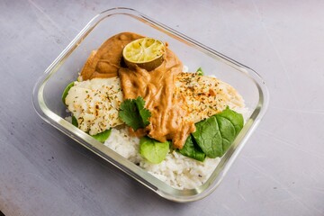 Top view of Grilled salmon bento in transparent tray for food delivery