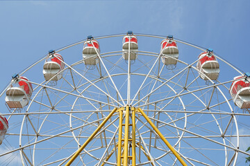 carnival, Ferris wheel over blue sky in amusement park in summer