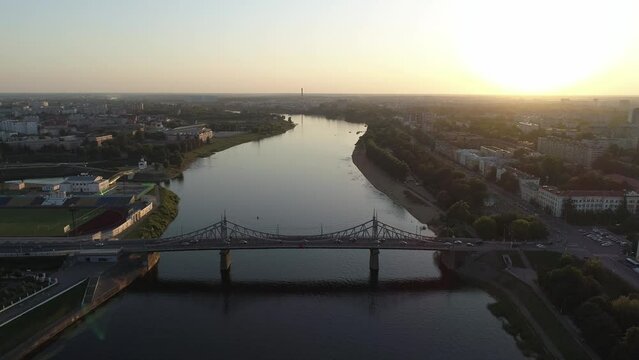 Aerial view of the road bridge across the river at sunset. Beautiful cityscape