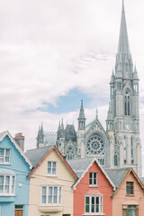 Row of colorful homes in front of cathedral in Cobh, Ireland