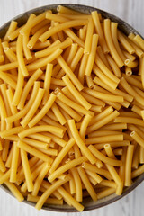 Dry Organic Maccheroni Pasta in a Bowl, top view. Flat lay, overhead, from above. Close-up.