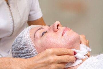 Obraz na płótnie Canvas A cosmetologist performs spa treatments with the face of a young pretty woman.