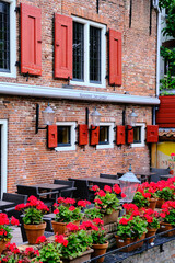 Fototapeta na wymiar Amersfoort, The Netherlands, July 6, 2022. Bright red shutters on an old Italian restaurant.