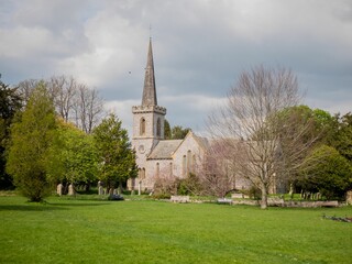 Stanmer church surrounded by growing trees and greenery field in Brighton © Anton Herrmann/Wirestock Creators
