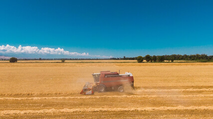 Aerial view of Combine Harvester Harvesting Wheat In Agricultural Field