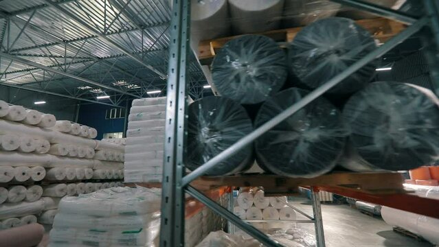 Large modern warehouse in the factory. Large warehouse in a nonwovens factory. Industrial interior. Lots of big rolls of spunbond. Warehouse with rolls of nonwovens.