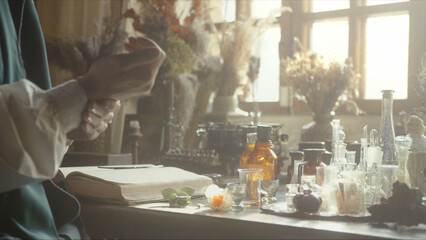 A close-up of a perfumer at his desk looking for a new fragrance. Vintage cinematic concept. Sunny...