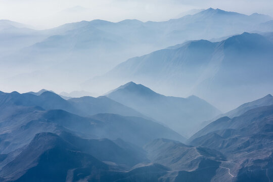 The hazy Peruvian Andes Mountains seen from above in an airplane view