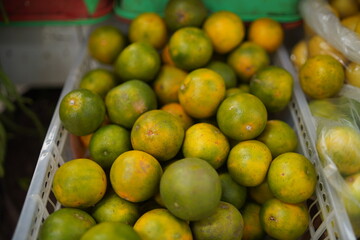 Fresh green and yellow local oranges sold in the traditional market