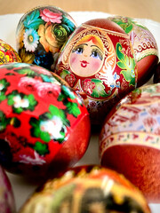 Vertical closeup shot of orthodox easter decorated eggs with illustrations of matryoshka