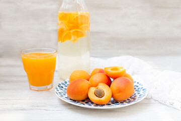 Delicious ripe apricots in on a blue plate on the table close-up. Freshly squeezed fruit juice. A healthy breakfast.  