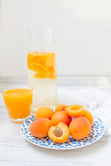 Delicious ripe apricots in on a blue plate on the table close-up. Freshly squeezed fruit juice. A healthy breakfast.  