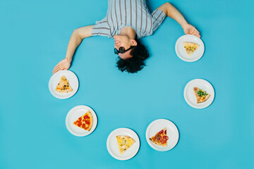 A young man juggles pizza slices. Pizzeria advertising concept.