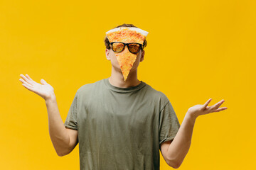 The pizza man. A guy with a piece of pizza on his face poses on a colored background. Creative...