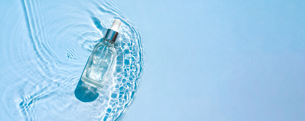 Moisturizing cosmetic product, serum, gel, emulsion in a transparent bottle with a pipette in water waves, blue background