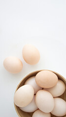 brown chicken eggs on a light plate on a white background