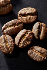 Roasted coffee beans isolated close up on black background, clipping path