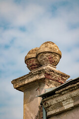 Two old, damaged spherical architecture elements made out of bricks on a roof of a building