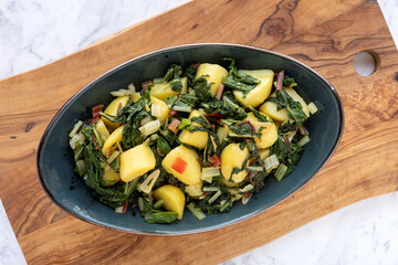 Potatoes with swiss chard leaves. South Croatian Blitva dish made with boiled potatoes, swiss chard, garlic and olive oil.