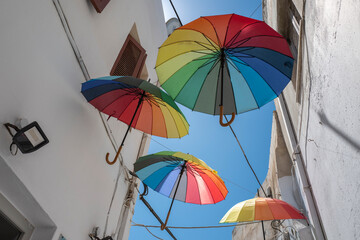 Bunte Schirme am Himmel in Gasse auf Naxos