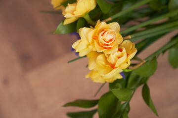 Yellow terry daffodils on a wooden background. Bouquet of beautiful yellow and orange Narcissus flowers on a beige background. Spring background with copy space. High quality photo